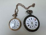 deux montres à gousset posées l'une à côté de l'autre sur une table