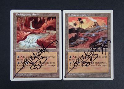 two cards with autographs on them are sitting on a table