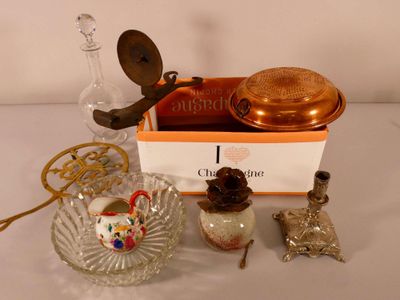 une boîte contenant une bougie, un bougeoir, un bol en verre et une bougie posée sur une table