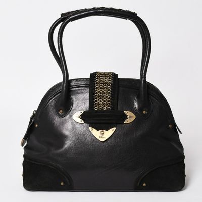 a black handbag with a gold metal handle on a white background