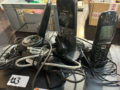 two phones and a charger sitting on a table
