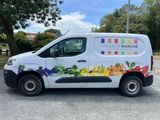 the van is parked in the parking lot with a colorful design on the side