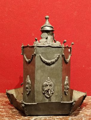un petit objet métallique posé sur une table avec un fond rouge