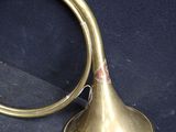 a brass trumpet sitting on a blue surface next to a mirror