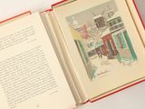 un livre ouvert sur lequel figure l'illustration d'une scène de rue
