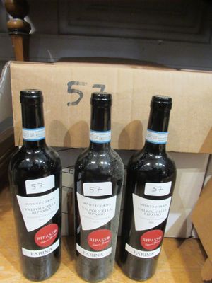 trois bouteilles de vin sont posées sur une table devant une boîte en carton