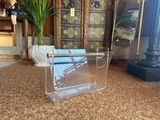 a clear plastic magazine holder sitting on the floor