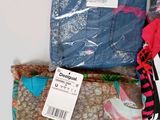 three bags of clothing sitting on a white surface