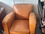 a brown leather chair and a brown chair in a room
