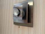 un gros plan d'un distributeur de papier toilette en acier inoxydable fixé au mur