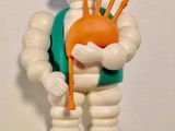 une figurine représentant un homme tenant une cornemuse dans ses mains
