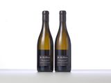 two bottles of white wine sitting on top of a table