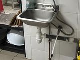 a kitchen with a sink and a shelf with dishes on it