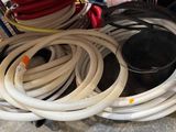 a pile of hoses and a bucket of water on the floor