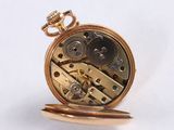 a gold pocket watch on a white surface