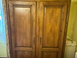 une grande armoire en bois dans le coin d'une pièce