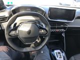 someone is sitting in the driver ' s seat of a car with their feet on the steering wheel