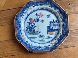 a blue and white plate sitting on a wooden table