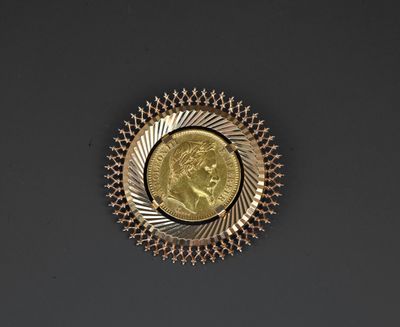 a close up of a gold medal with a coin in the center