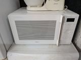 un micro-ondes blanc posé sur un four à micro-ondes