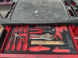 a red tool box with tools in it on a table