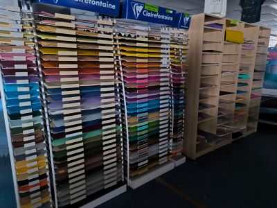 a lot of different colors of paper on the shelves in the store