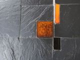 un mur recouvert de carreaux noirs ornés de carrés orange