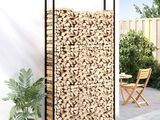 a close up of a firewood rack on a patio next to a chair