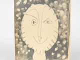 une vieille photo représentant un dessin d'un visage sur une feuille de papier