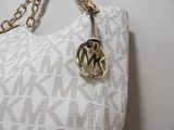 a white purse with a gold chain hanging from it