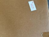 une boîte en carton avec un autocollant posé sur le sol
