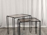 un ensemble de trois tables gigognes en verre posées sur un parquet