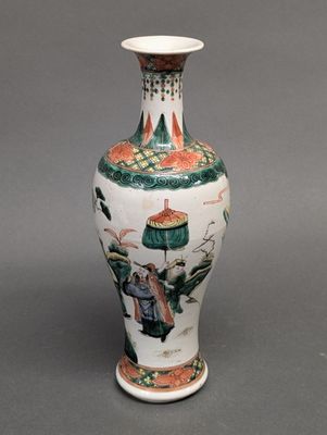 a vase with a painting on it sitting on a table