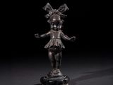 une statue en bronze représentant une jeune fille avec un nœud sur la tête et un nœud sur la tête