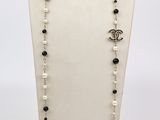 un collier avec un mannequin blanc orné de perles noires et blanches