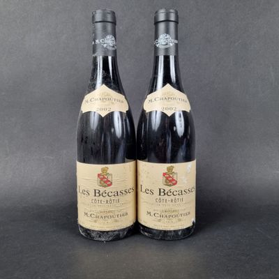 two bottles of red wine sitting next to each other on a table