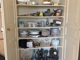 a pantry with a lot of dishes and dishes on the shelves