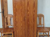 two wooden chairs and a cabinet in a room