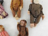 five stuffed animals sitting in a circle on a white surface