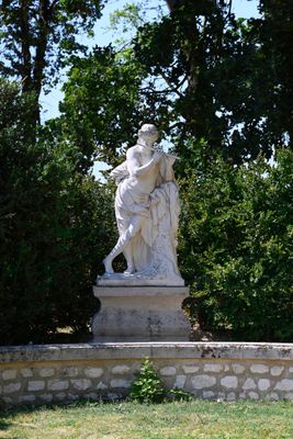 a statue in the middle of a park with trees in the background