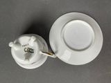 a cup and saucer sitting on a table next to a saucer