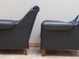 pair of black leather club chairs with studded arms