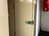 un réfrigérateur blanc dans une pièce où se trouve une borne d'incendie rouge accrochée au mur