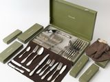 a green case with silverware in it on a white surface