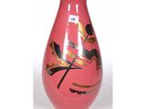 un vase rose orné de motifs dorés et noirs