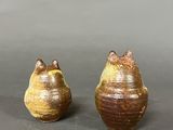 pair of ceramic vases with cats on them sitting on a table
