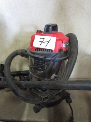 un aspirateur rouge et noir sur lequel est apposée une étiquette
