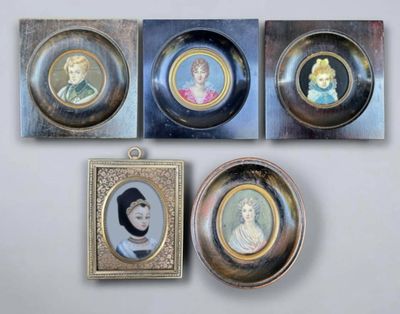 Quatre portraits encadrés représentant des femmes et des enfants sont accrochés au mur