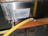 un tuyau jaune fixé sur le côté d'un four en métal