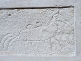 une image représentant une plaque en pierre sur laquelle figurent un cheval et son cavalier